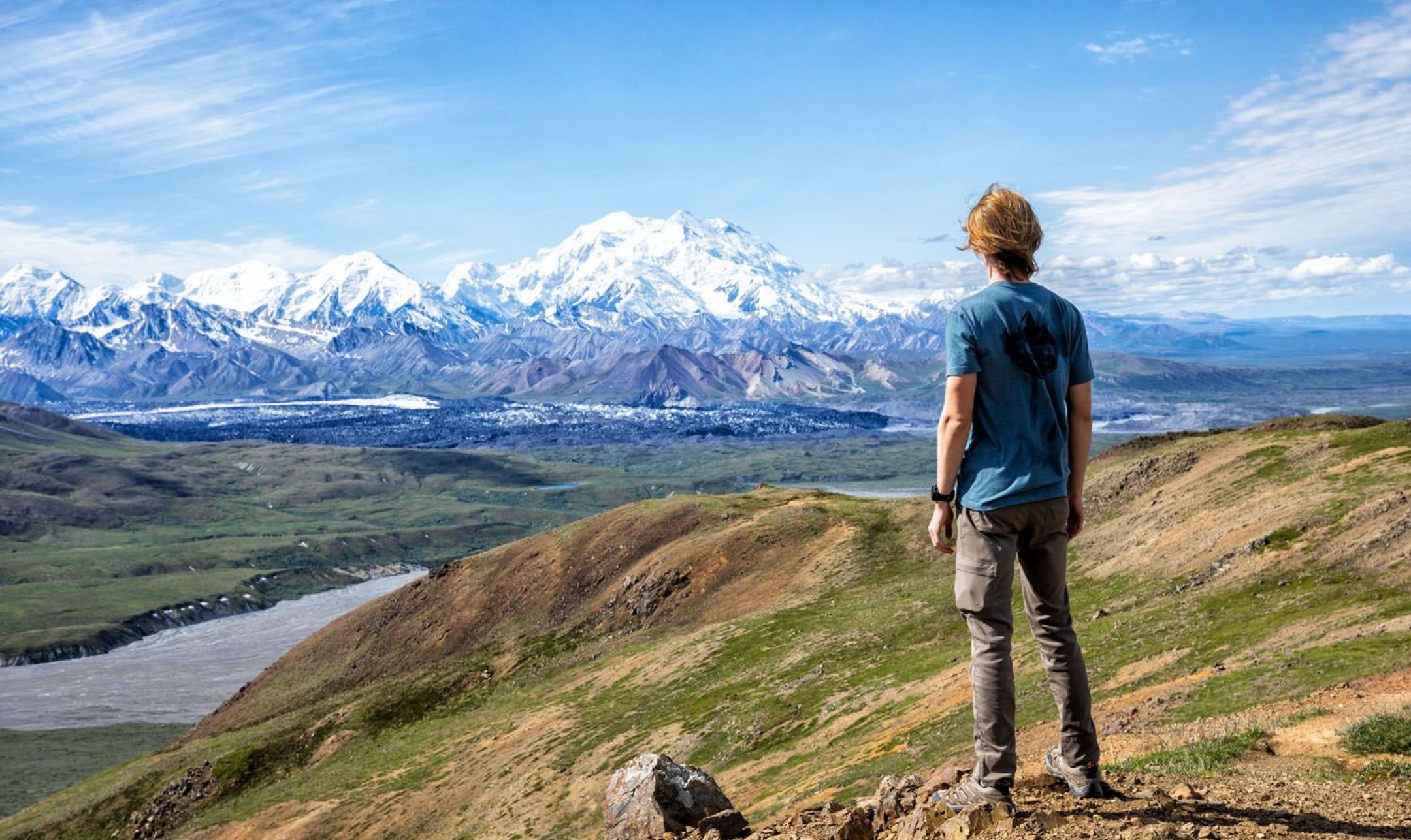 Man standing on cliff looking at mountains